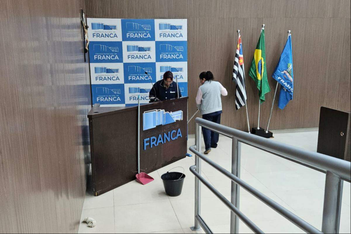 Funcionárias da limpeza enxugando o espaço onde fica a tribuna da Câmara Municipal de Franca